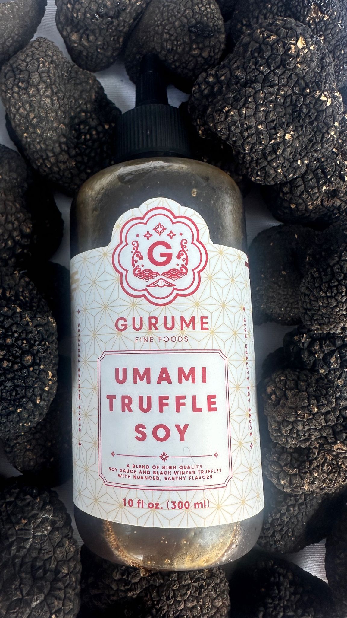 Gurume Umami Truffle Soy Sauce bottle surrounded by fresh black truffles, 10 fl oz